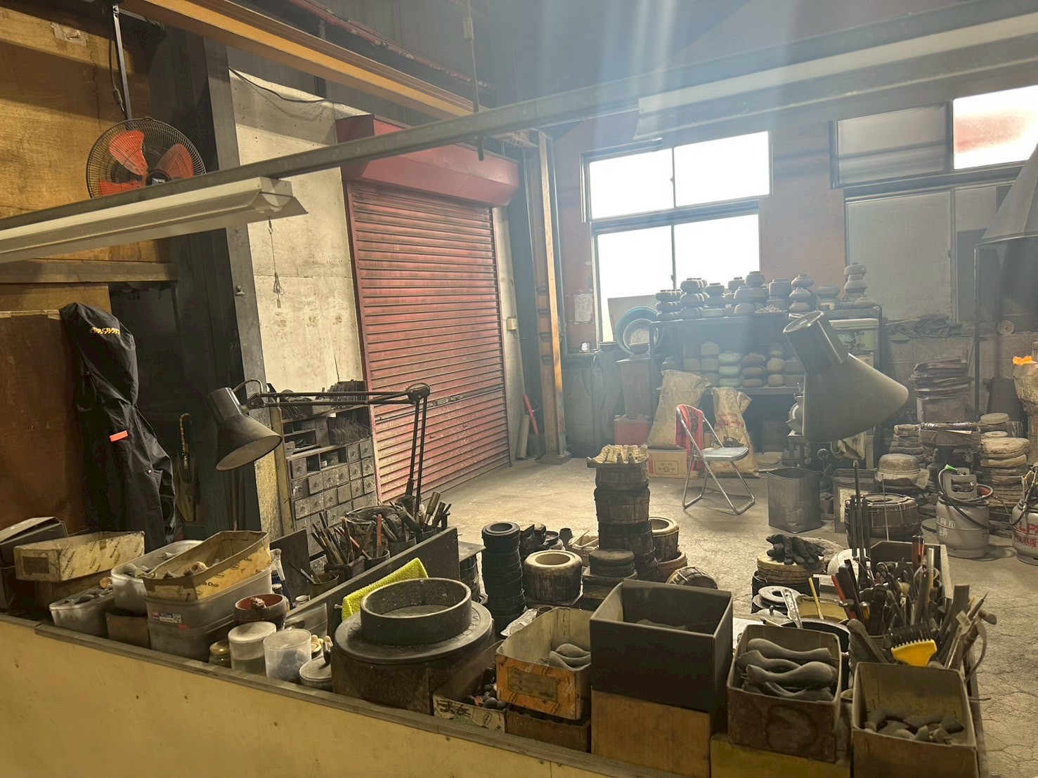 作業台に並ぶ工具、箱に分けられた道具、赤いシャッター